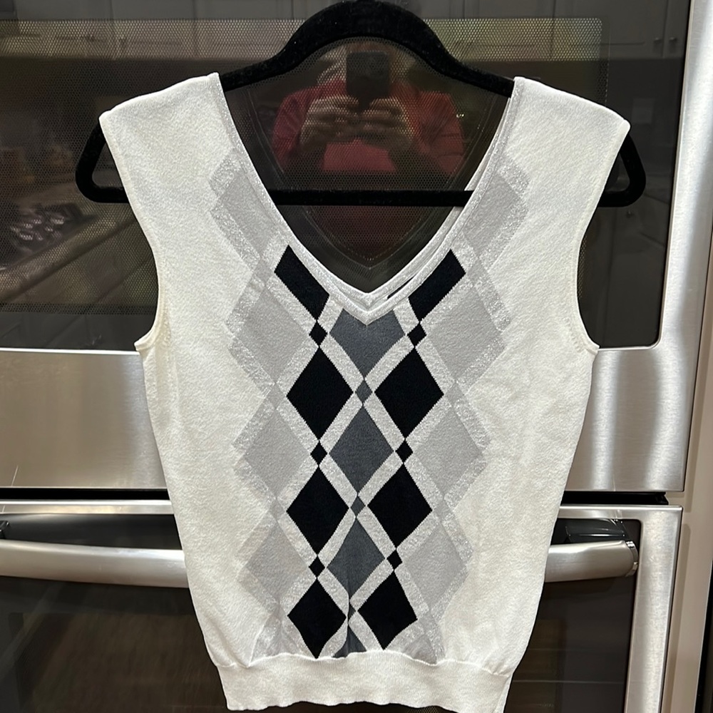 Sleeveless v-neck lightweight top. It is off white black, 2 grays and silver
